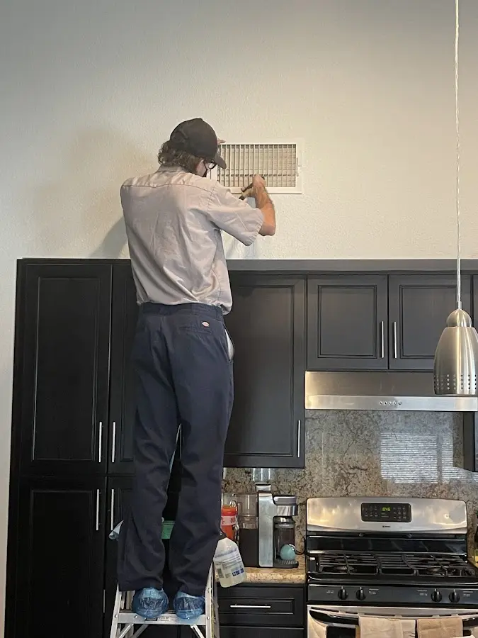 Technician inspecting an air vent during HVAC service in Eucalyptus Hills